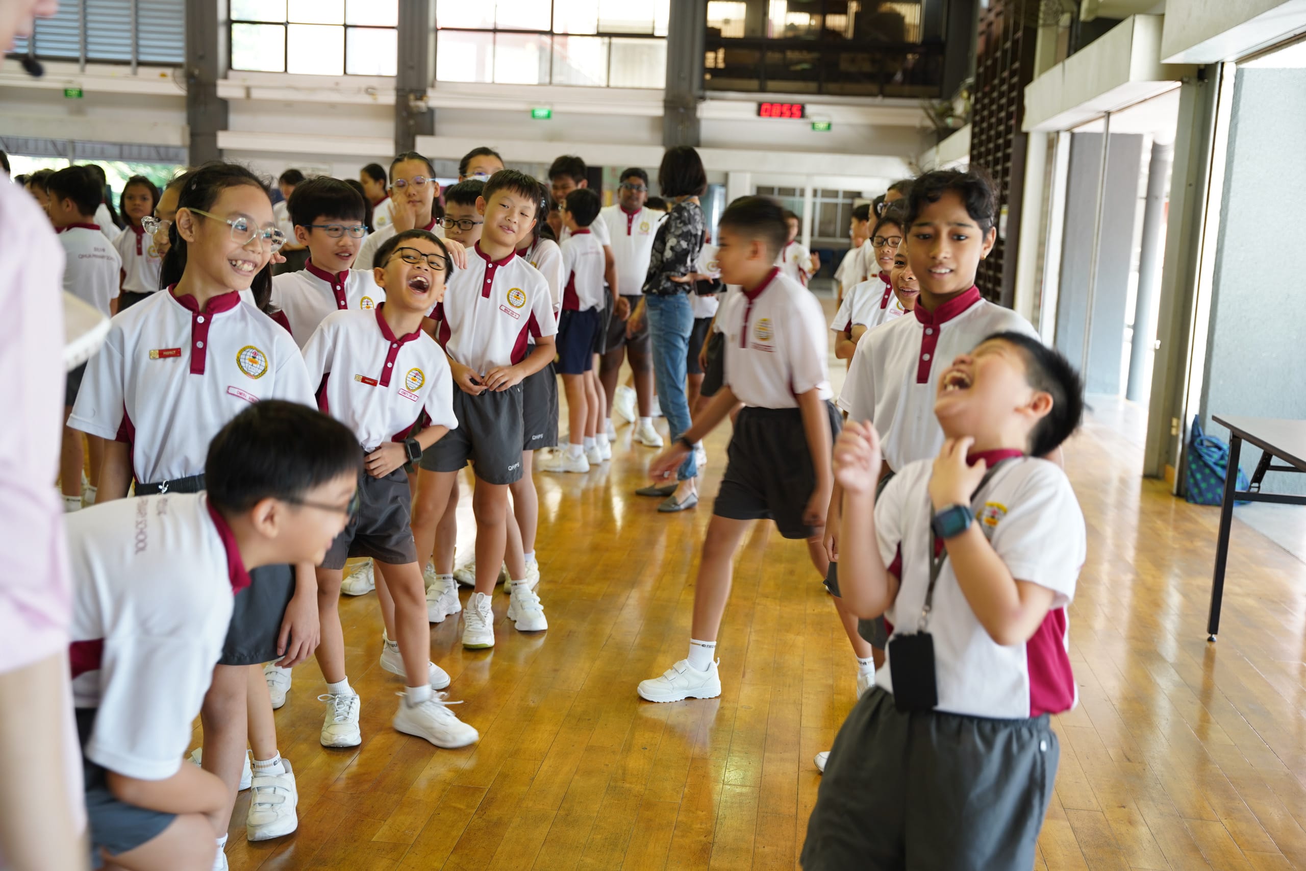 Students laughing while playing bonding games in the school hall